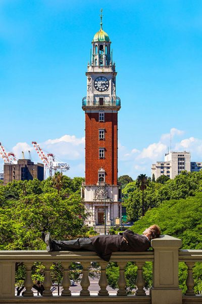 Un'uomo riposa di fronte alla Torre Monumentale di Buenos Aires
